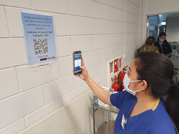A nurse scans the Class Attendance Tracker (CAT) QR code
