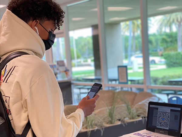 A student scanning out of school with his CAT QR mobile app