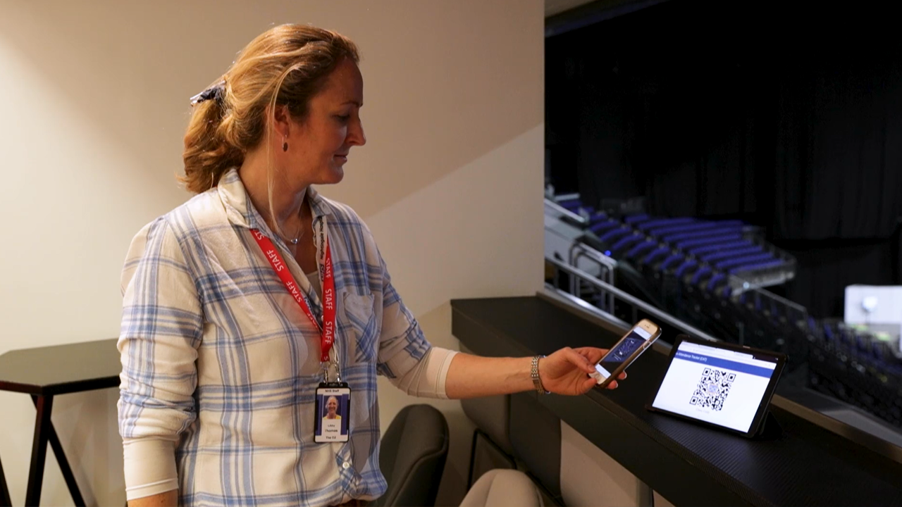 A woman uses the CATQR mobile app to sign into training at the NHS Nightingale Hospital London.