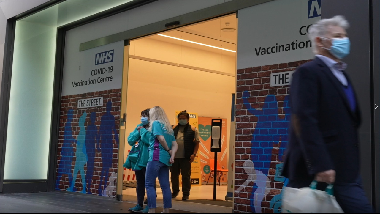 Volunteers standing outside an NHS COVID-19 Vaccination Centre.